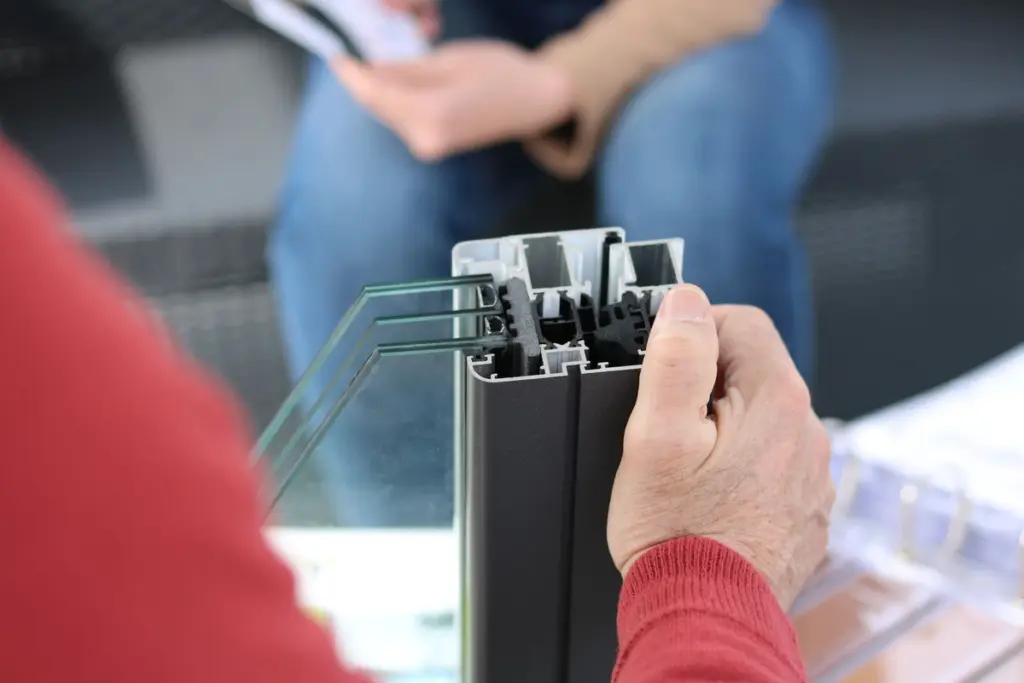 Corte de un perfil de aluminio de ventana sostenido en la mano