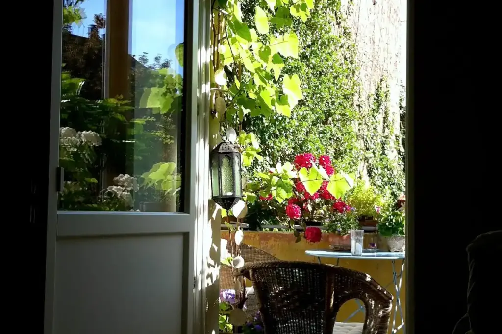 Puerta abierta a una terraza con plantas en verano